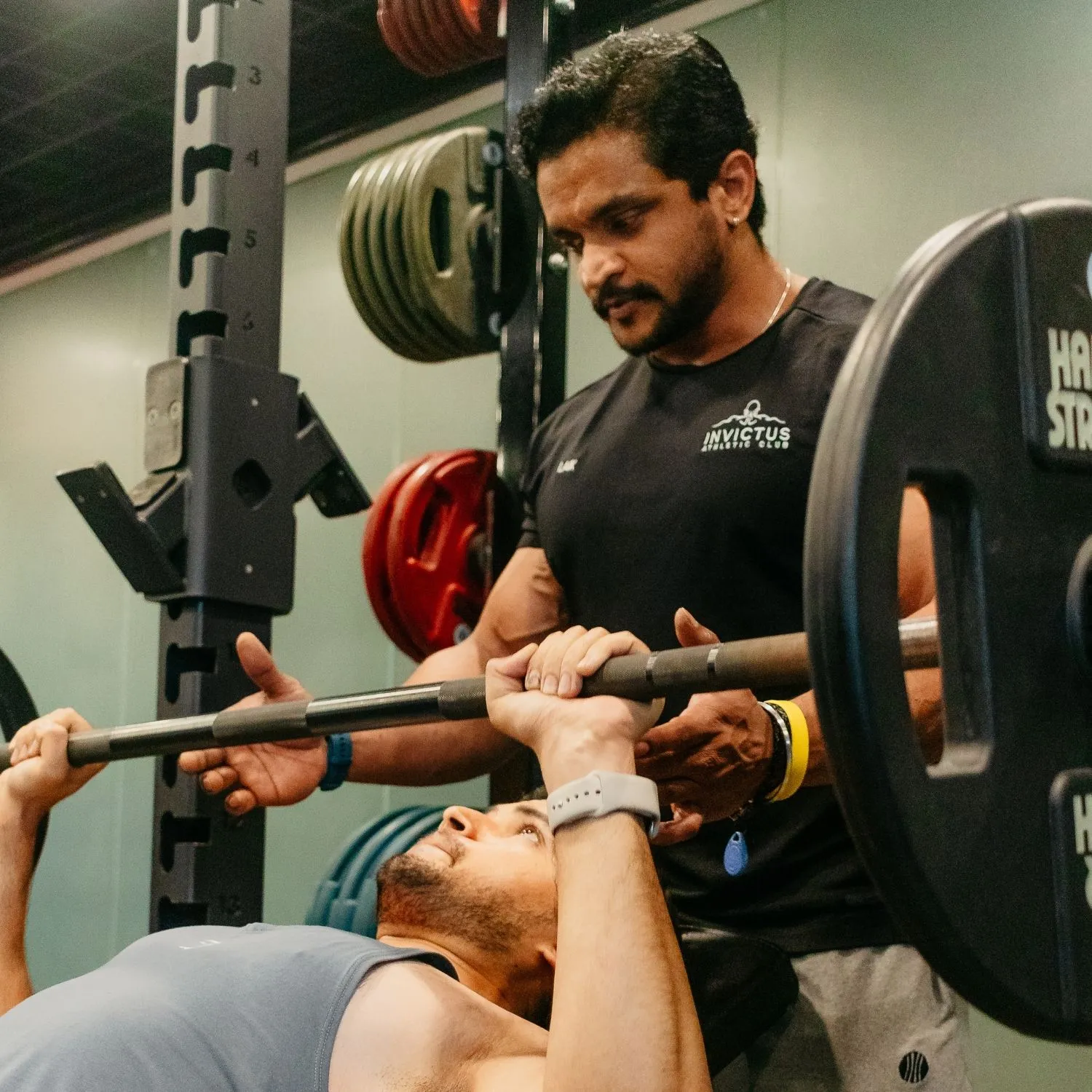Coach spotting a barbell bench press